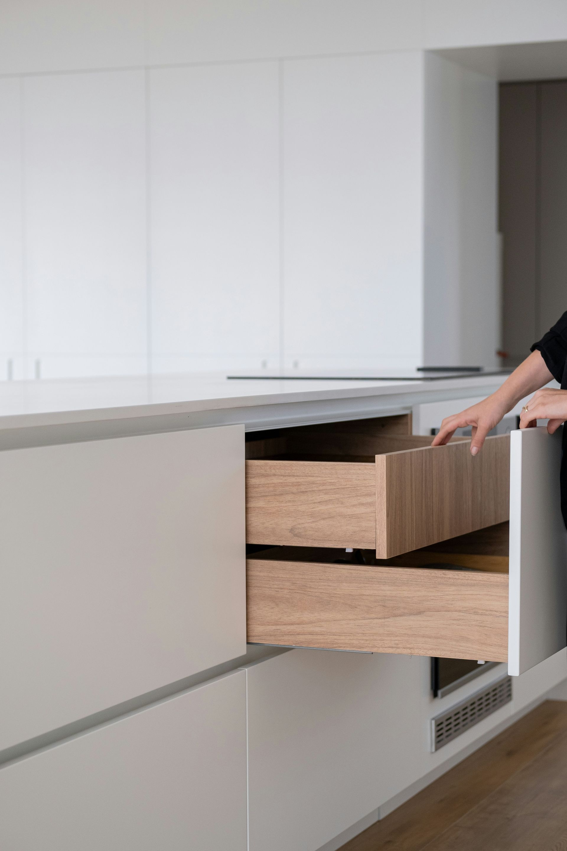A person opens a modern kitchen drawer